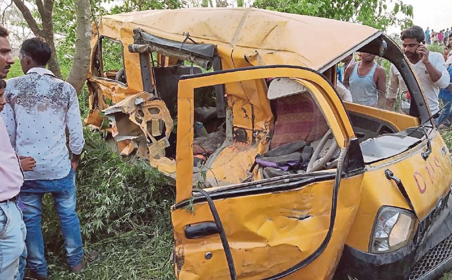 PENDUDUK melihat van sekolah yang remuk selepas dirempuh kereta api di daerah Kushinagar di Uttar Pradesh, India semalam. - EPA