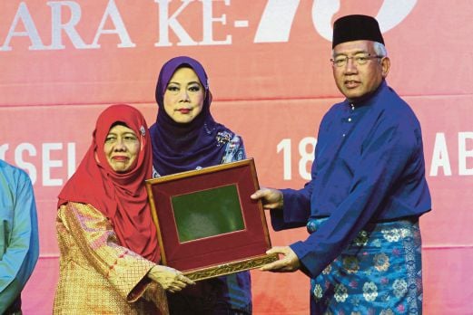  Mahdzir  menyampaikan anugerah kepada   Dr Zurinah pada Majlis Pengurniaan Anugerah Sastera Negara Ke-13, semalam.