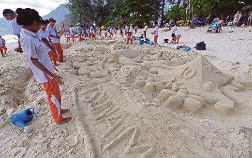 PELAJAR  Thai membuat skulptur pasir sempena memperingati ulang tahun ke-10 kejadian tsunami di Phuket, semalam. 