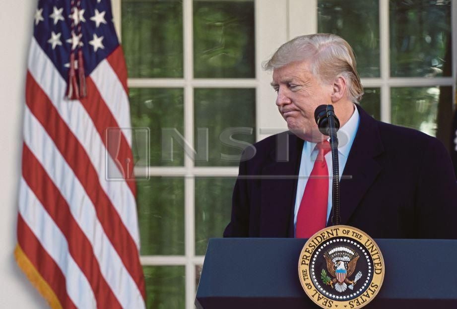 REAKSI  Trump ketika meninggalkan podium di Rumah Putih selepas mengumumkan pembukaan kembali kerajaan, semalam. - EPA