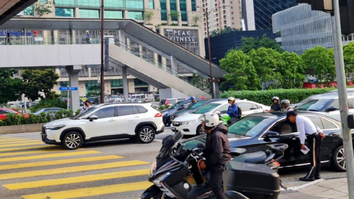 ANGGOTA polis mengambil tindakan ke atas kenderaan yang berhenti di garisan kuning, laluan pejalan kaki. FOTO Ihsan Polis.