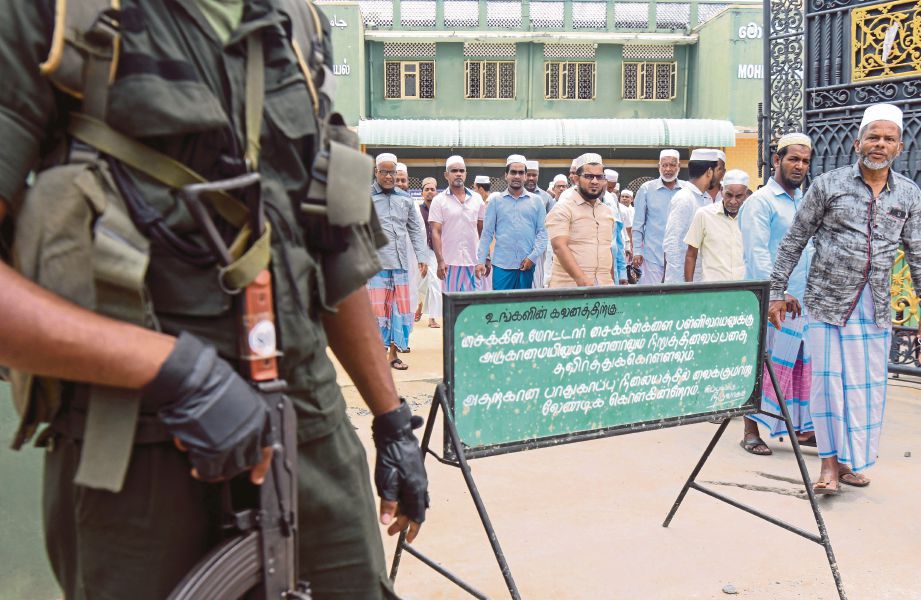 PEGAWAI keselamatan Sri Lanka berdiri di luar masjid ketika solat Jumaat di Kattankudy. - AFP