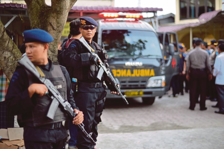 POLIS berkawal  berhampiran ambulans yang membawa keranda Aiptu, anggota polis yang terbunuh selepas ditikam dalam serangan di Medan kelmarin.  - EPA 