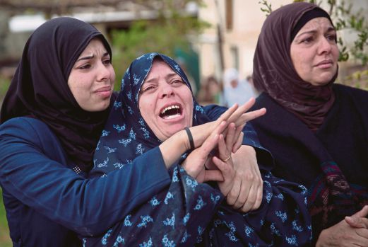 ANGGOTA keluarga Yehya menangis ketika majlis pengebumiannya di Qattana.