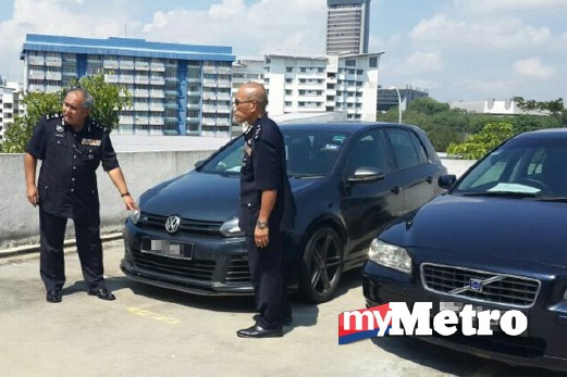 ADNAN (kiri) menunjukkan kereta yang dirampas polis. FOTO Mohd Hasbi Sidek