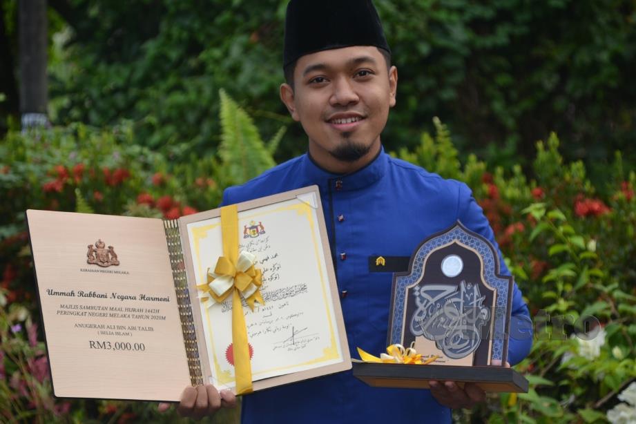 MUHAMMAD Fahmi ceria menerima anugerah daripada Kerajaan Melaka. FOTO Hassan Omar