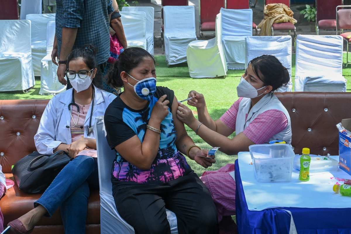 PETUGAS kesihatan menyuntik vaksin Covid-19 pada seorang wanita di pusat vaksinasi sementara di New Delhi. FOTO AFP 