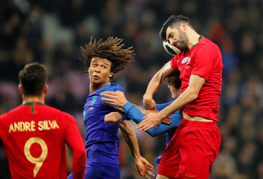 PEMAIN Belanda, Nathan Ake (tengah) mengekang pemain Portugal. FOTO/AFP   