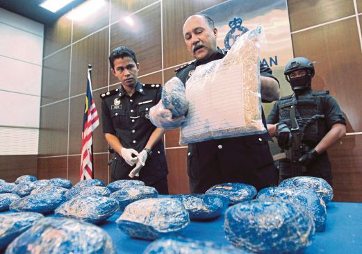 MOHD Mokhtar memegang dadah dan bungkusan makanan kuda yang dirampas.