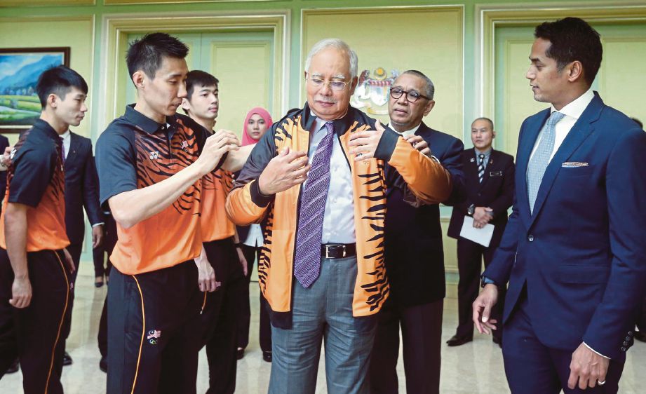 NAJIB dipakaikan pakaian rasmi kontijen negara oleh jaguh badminton negara, Datuk Lee Chong Wei.