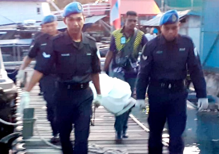 ANGGOTA polis mengangkat mayat lelaki dipercayai mangsa bot karam ke hospital. FOTO ihsan PPM