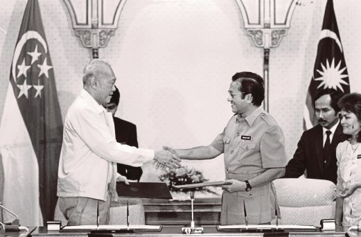 DR Mahathir dan Kuan Yew bertukar dokumen selepas menandatangani memorandum persefahaman di Kuala Lumpur pada 28 Jun 1988. 