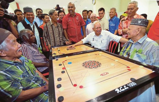 Najib meluangkan masa bermain karom bersama penduduk warga emas selepas merasmikan Kompleks Komuniti Muhibbah, semalam.