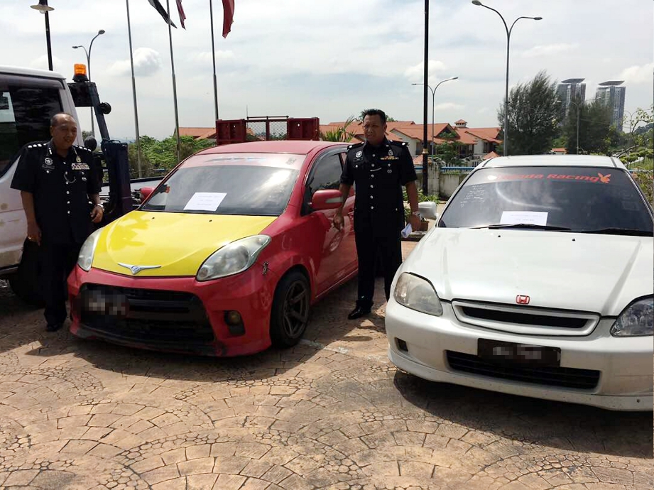 Mohd Megat Aminuddin (kiri)  memeriksa kereta curi dirampas daripada Geng Pokmat.