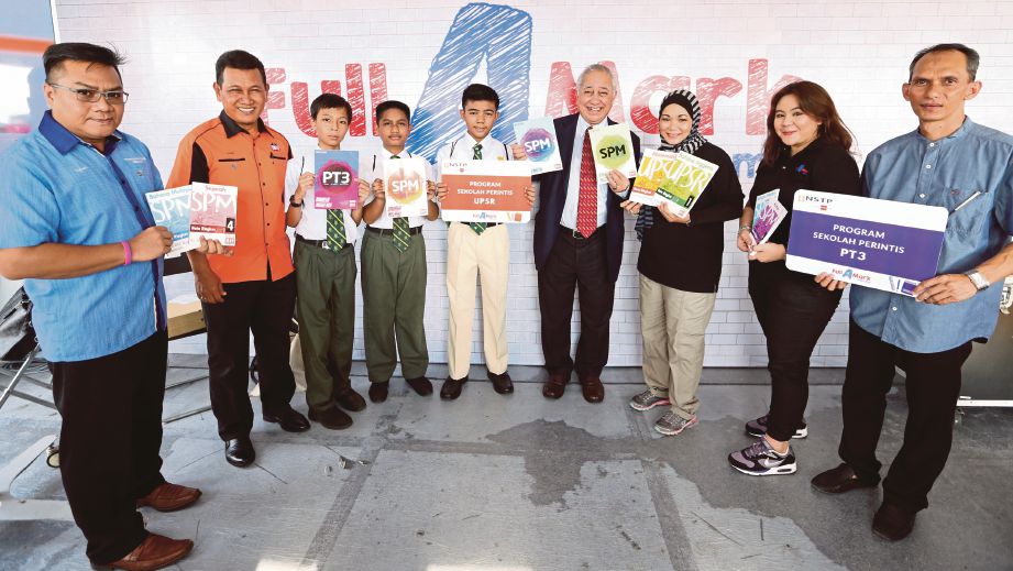 MOHAMED Ghazali (empat kanan) bersama sebahagian pelajar dua sekolah terpilih pada program portal pendidikan NSTP di Johor Bahru, semalam.   