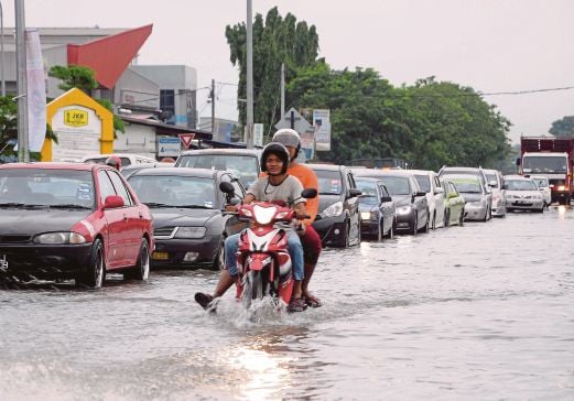 KESESAKAN lalu lintas di Jalan Sungai Rasau, Padang Jawa selepas kawasan tersebut di naiki air dalam kejadian banjir kilat. 