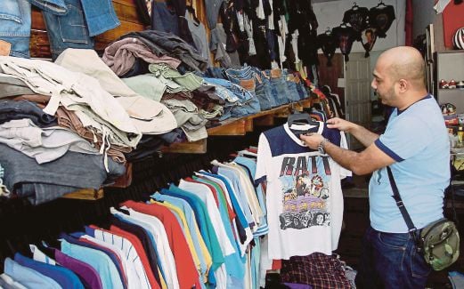 MOHD Shamsul menyusun pakaian agar pelanggannya mudah membuat pilihan.