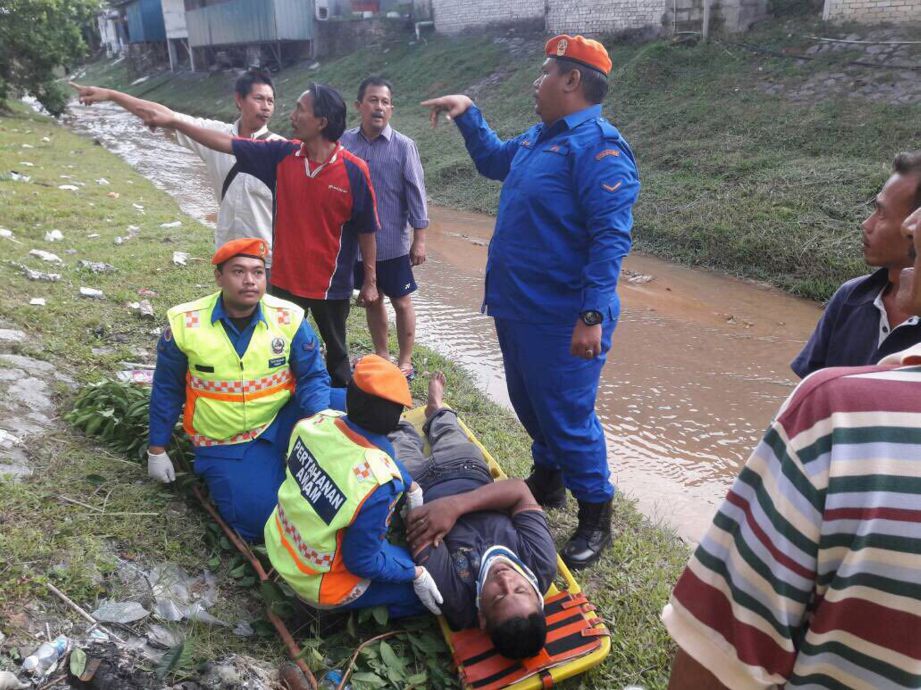 ANGGOTA APM memberi rawatan kepada mangsa yang parah akibat terjatuh pokok Serai Kayu di Jalan Melati 10, Gombak Setia.
