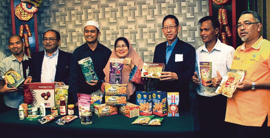 NAZIPAH (tengah) bersama pegawai FAMA menunjukkan produk tempatan Sabah pada Bengkel Fasilitasi Pengeksportan dan Penerokaan Pasaran Produk Sabah dan Sarawak ke Negara Timur Jauh. 