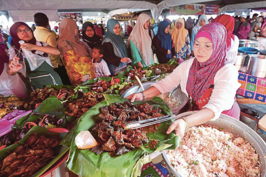 NORLIZA menyediakan pelbagai lauk-pauk untuk dijual di Bazar Ramadan Pasar Batu Enam.