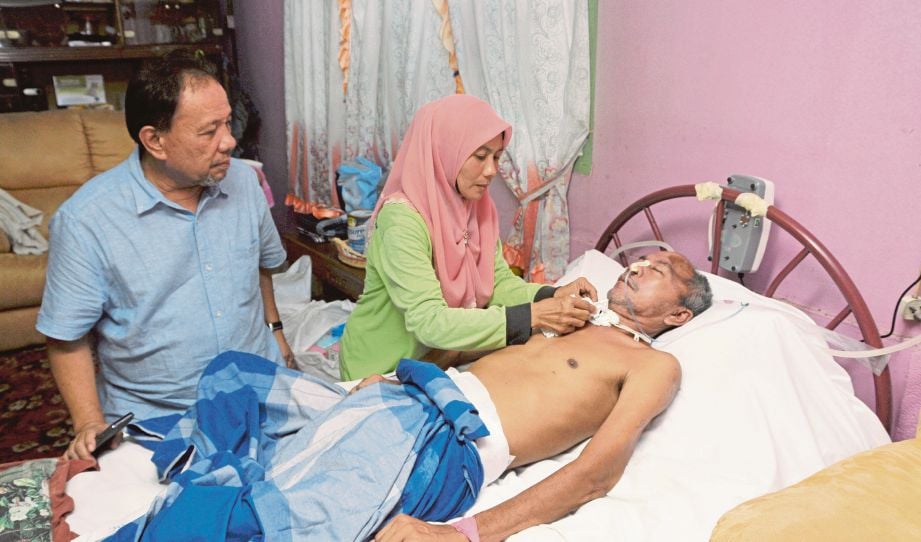Mastini   memeriksa leher  Abu Zarin  sambil diperhatikan  ADUN Senaling, Datuk Ismail Lasim di Kampung Kuala Dioh. 