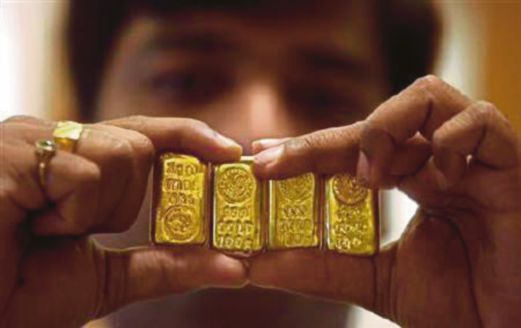 GAMBAR menunjukkan seorang lelaki memegang empat bar emas yang setiap satunya seberat 100 gram.