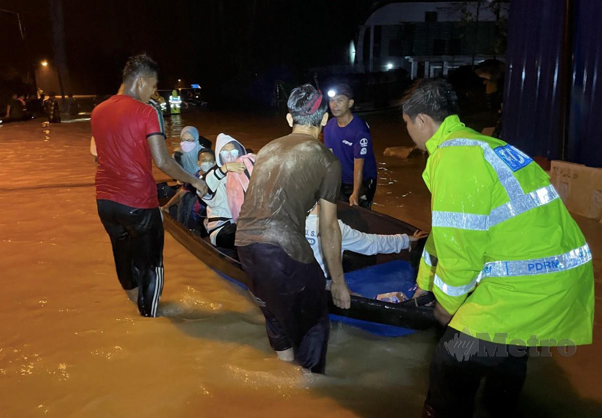 POLIS dan sukarelawan membantu memindahkan mangsa banjir yang terperangkap di Kampung Paya Besar, Kuala Berang. FOTO Ghazali Kori.