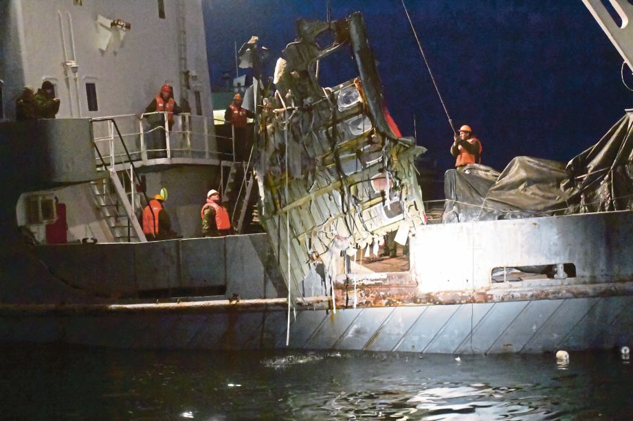 ANGGOTA pencarian menaikkan serpihan pesawat yang ditemui di Laut Hitam pada lewat Isnin. - AP
