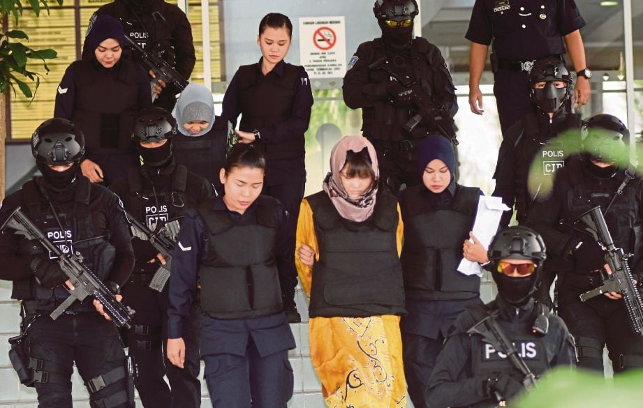 SITI Aisyah dan Doan diiringi anggota polis keluar dari Mahkamah Tinggi, semalam.