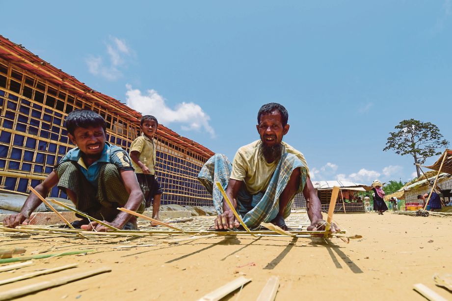 LELAKI Rohingya membuat pagar buluh sebagai persediaan menghadapi monsun di kem pelarian Kutupalong, Ukhia, Bangladesh. - AFP  
