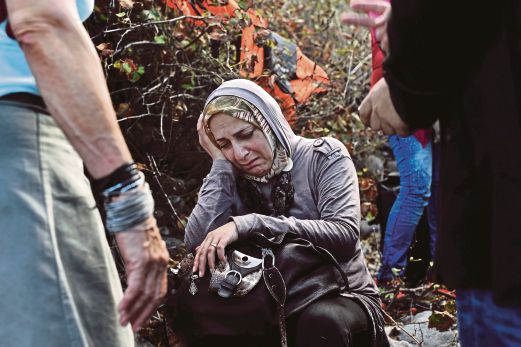 SEORANG wanita Syria menangis kesyukuran selepas selamat tiba di pulau Lesbos, Greece.
