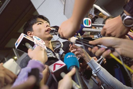 KETUA aktivis prodemokrasi, Joshua Wong bercakap kepada pemberita di luar mahkamah selepas dibebaskan dengan jaminan, semalam.