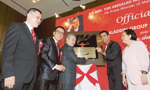ABDULLAH (tengah) menandatangani plak  sebagai pelancaran ibu pejabat Aladdin Group Global, semalam.