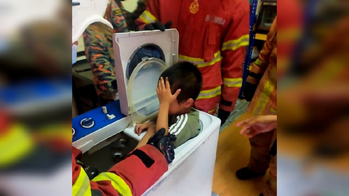 ANGGOTA bomba membantu mengeluarkan kanak-kanak lelaki yang tersangkut di dalam pengering mesin basuh. FOTO Ihsan Bomba.