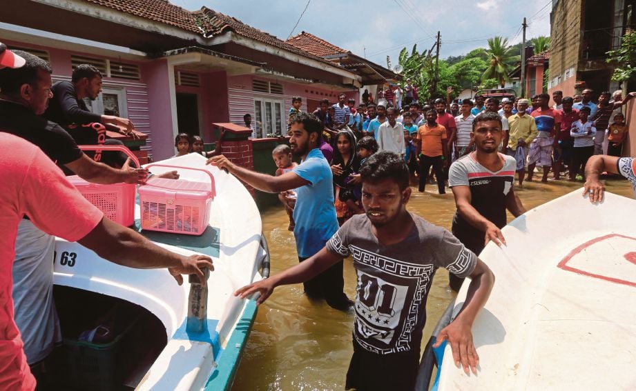 MANGSA banjir di daerah Kalutara di Sri Lanka menanti untuk dipindahkan.  - AP