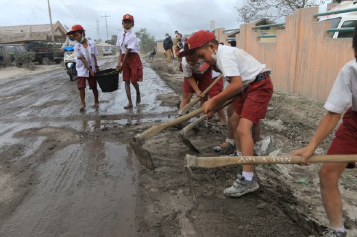 MURID sebuah sekolah rendah di Kampung Gajah, Sumatera Utara membersihkan debu gunung berapi di sekolah mereka. 