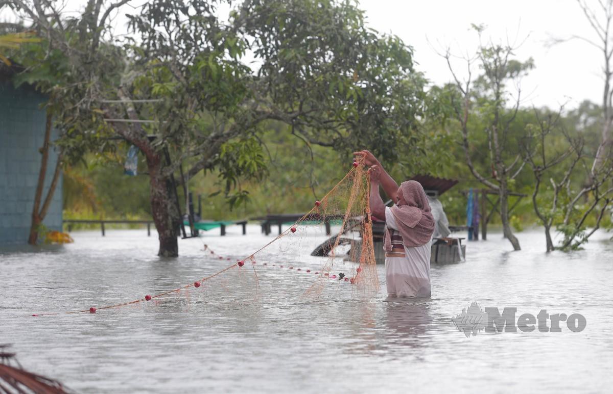 MANGSA banjir, Awang Mad Yahya Noh melihat pukat yang dipasang di hadapan rumahnya di Kampung Perpat, Sedili,  Johor. FOTO Nur Aisyah Mazalan.