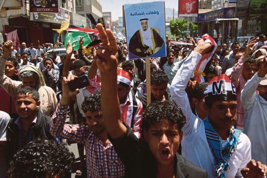PENDUDUK di Taiz, bandar ketiga terbesar di Yaman,  menjulang poster Raja Arab Saudi, Salman, ketika menunjuk  perasaan menyokong serangan yang diketuai Riyadh, semalam. 
