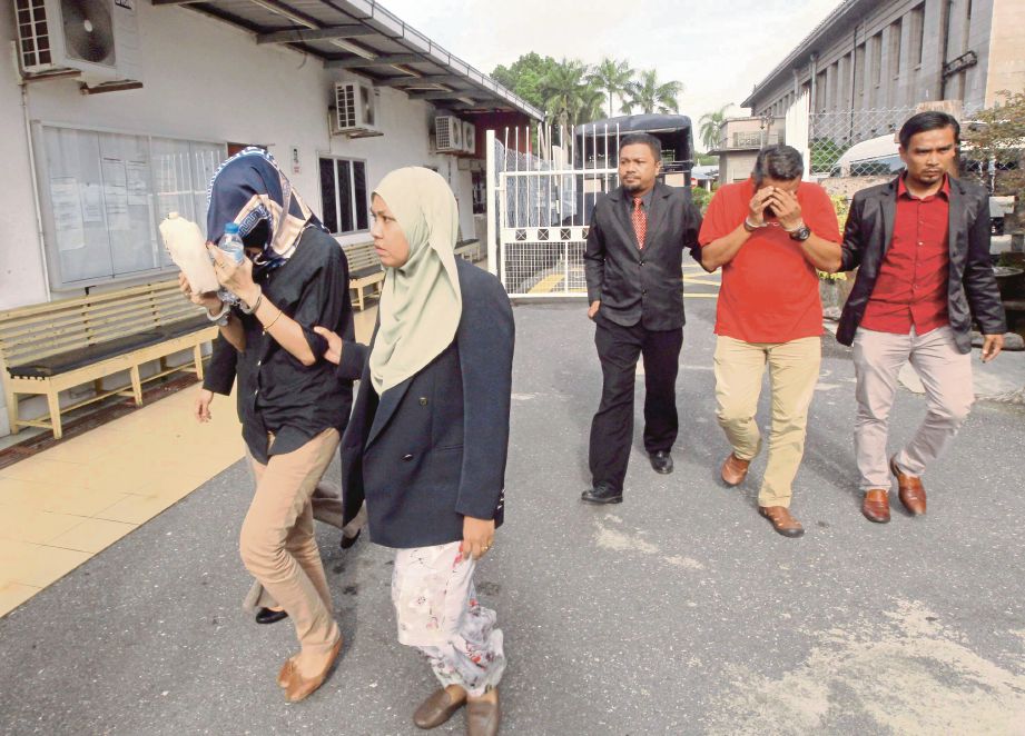 ANGGOTA SPRM mengiringi Norfadilla dan Mohd Fadzril keluar dari Mahkamah Sesyen Kangar, semalam.