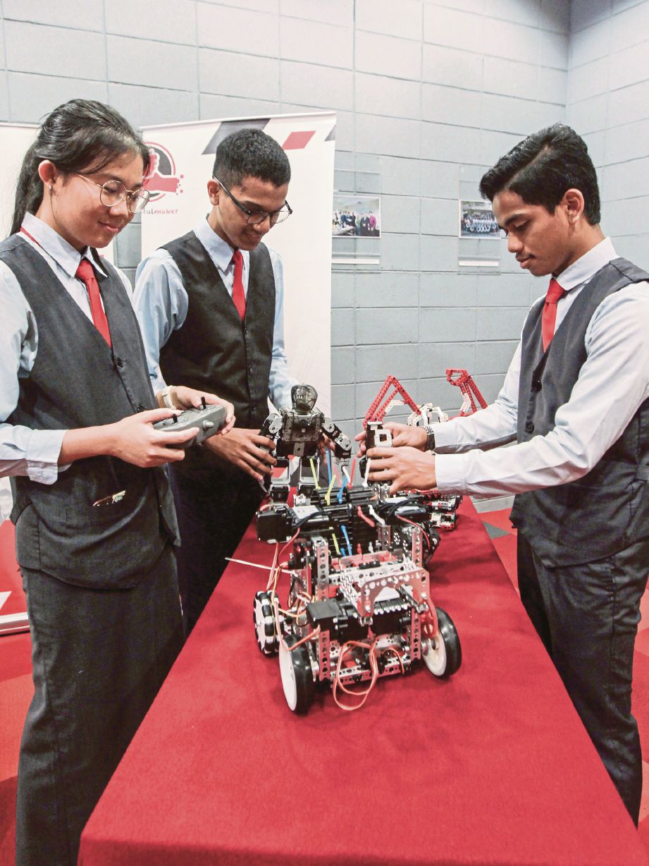 DARI kiri: Loo, Harun dan Ahmad Azzam membuat demonstrasi menggunakan robot.