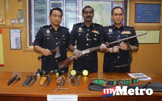 KUMAR (tengah) menunjukkan senjata pemburu yang dirampas. FOTO Mohd Sah Muda