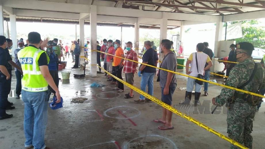 PIHAK berkuasa melakukan persiapan bagi menghentikan aktiviti membeli hasil laut di Pasar Bisik Kuala Muda, Penaga. FOTO ihsan Polis