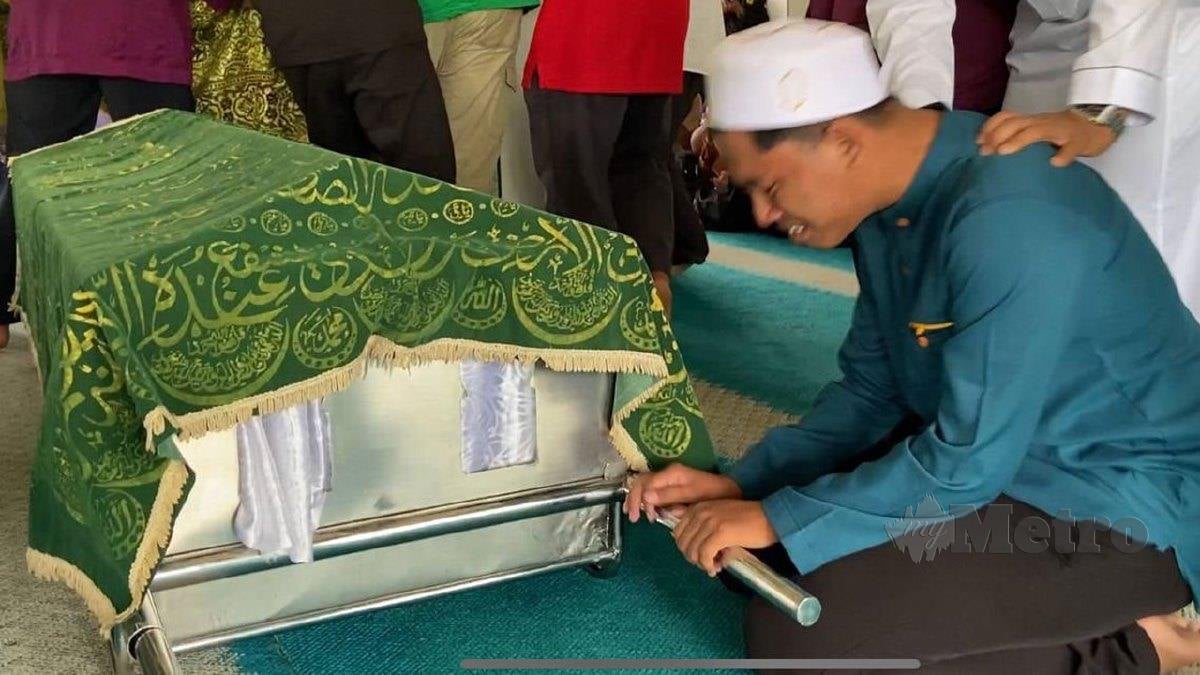 ABDUR Rahman meratapi jenazah ahli keluarganya di Masjid Ubuddiah, Parit Limbong. FOTO Alias Abd Rani