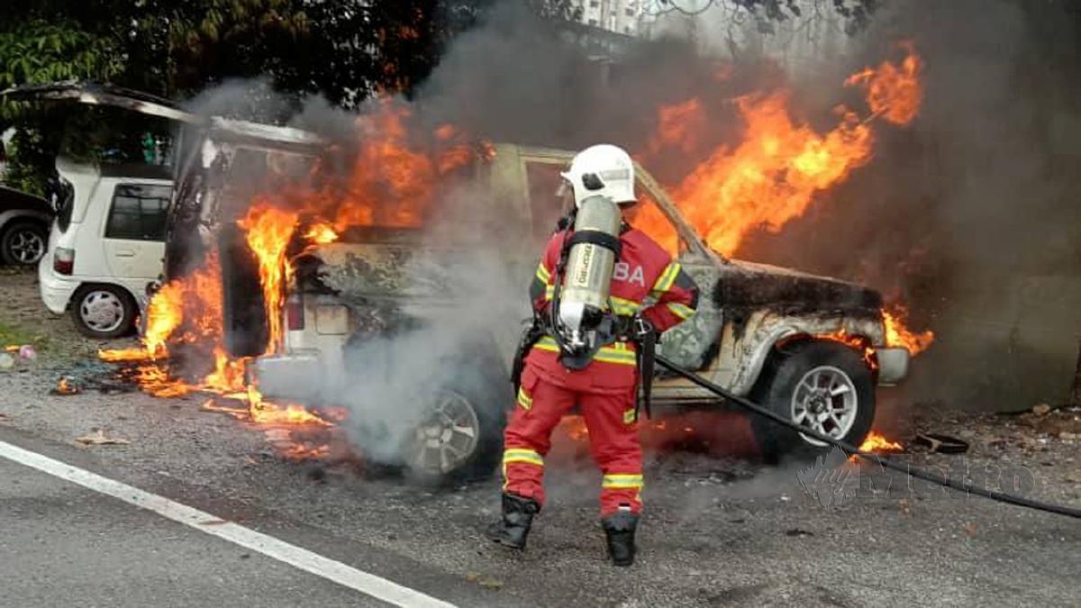 ANGGOTA bomba berusaha memadamkan kebakaran yang menyebabkan empat kenderaan musnah. FOTO ihsan Bomba