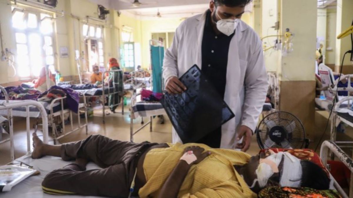 DOKTOR membantu pesakit yang dijangkiti ‘kulat hitam’ di sebuah hospital di India. FOTO fail AFP 
