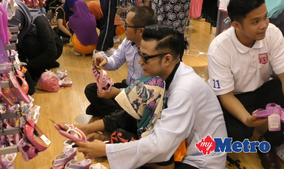 Pak Nil bersama seorang daripada 180 kanak-kanak dan remaja membeli-belah sempena Aidilfitri. FOTO Saiful Iskandar Ismail