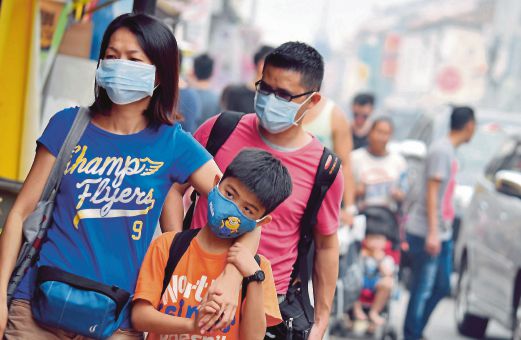 PELANCONG memakai topeng penutup hidung dan mulut ketika bersiar-siar bersama keluarga di sekitar Jonker Walk, Melaka.