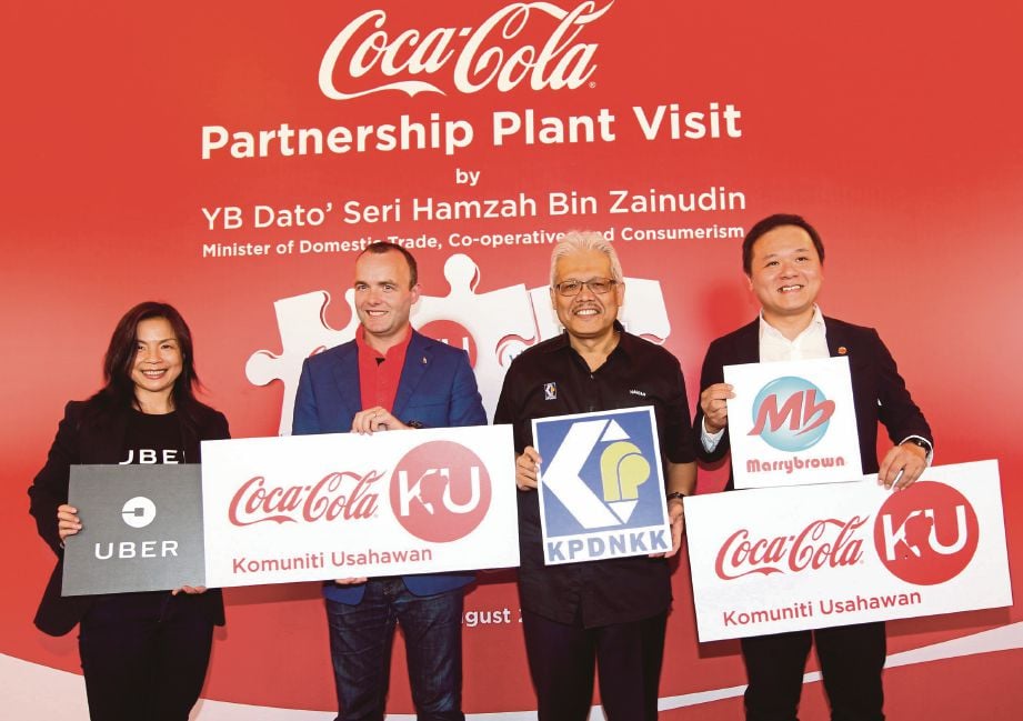HAMZAH (dua dari kanan) bersama  Gareth  (dua dari kiri), Ketua Pegawai Eksekutif Marrybrown Sdn Bhd, Datuk Joshua Liew (kanan) serta Pengurus Pemasaran Uber Malaysia, Geraldine Wong di Kilang Coca-Cola Bandar Enstek, semalam.