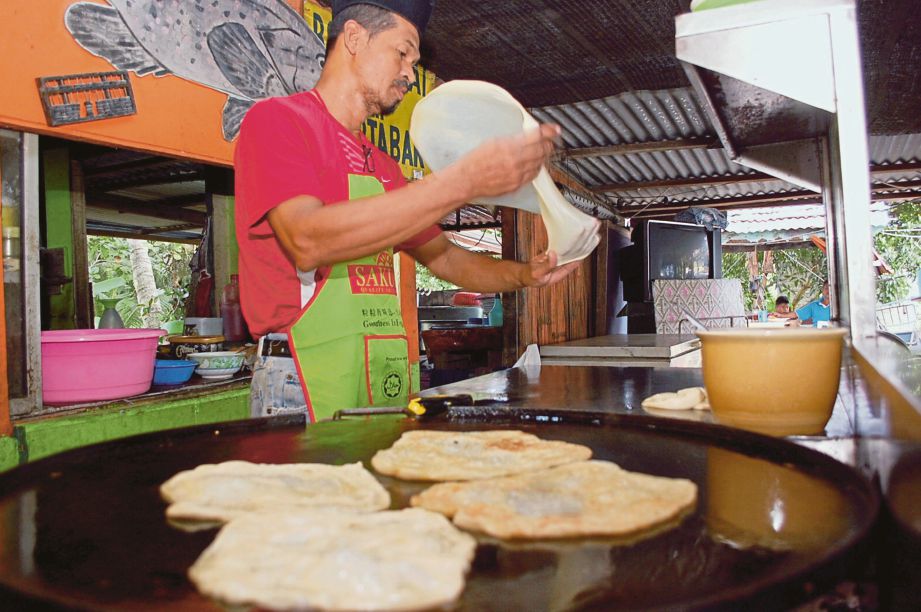 ALIAS menyediakan roti canai di gerainya di Kampung Londang, Masjid Tanah.