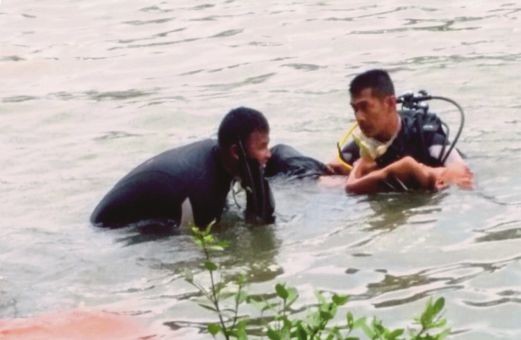 ANGGOTA mengangkat mayat mangsa yang lemas di muara sungai Kuala Ibai. 